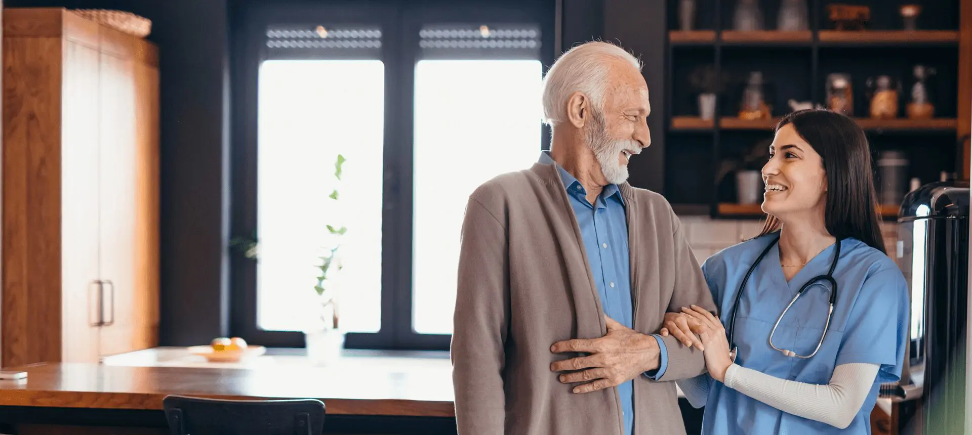 Caregiver helping elderly man indoors