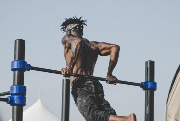 A man is doing pull ups on bars