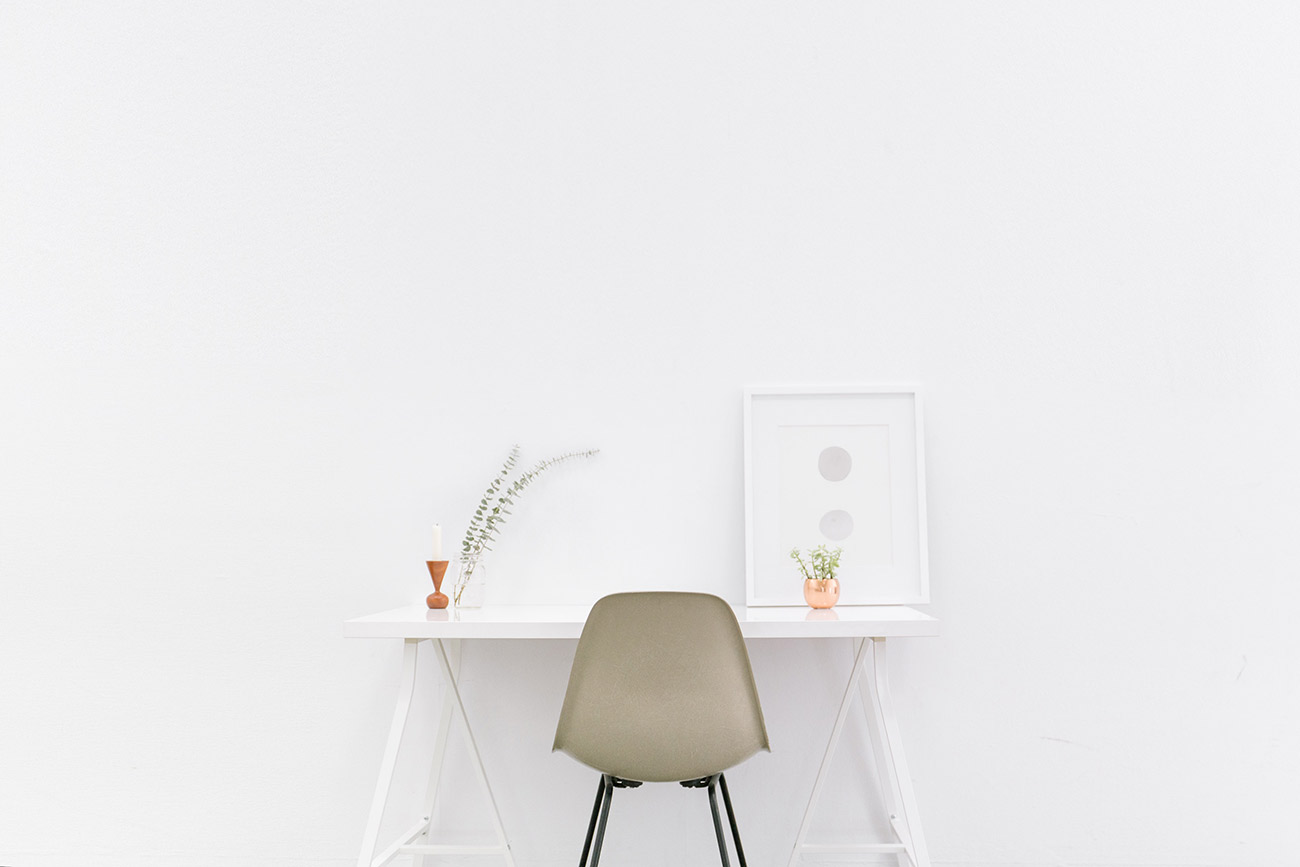 A chair and table in front of a wall.