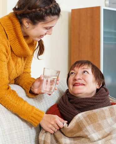 A woman and her daughter are smiling at each other.