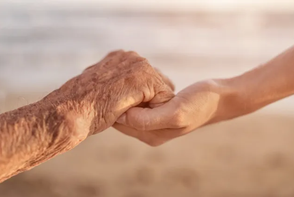 A person holding hands with an old person.