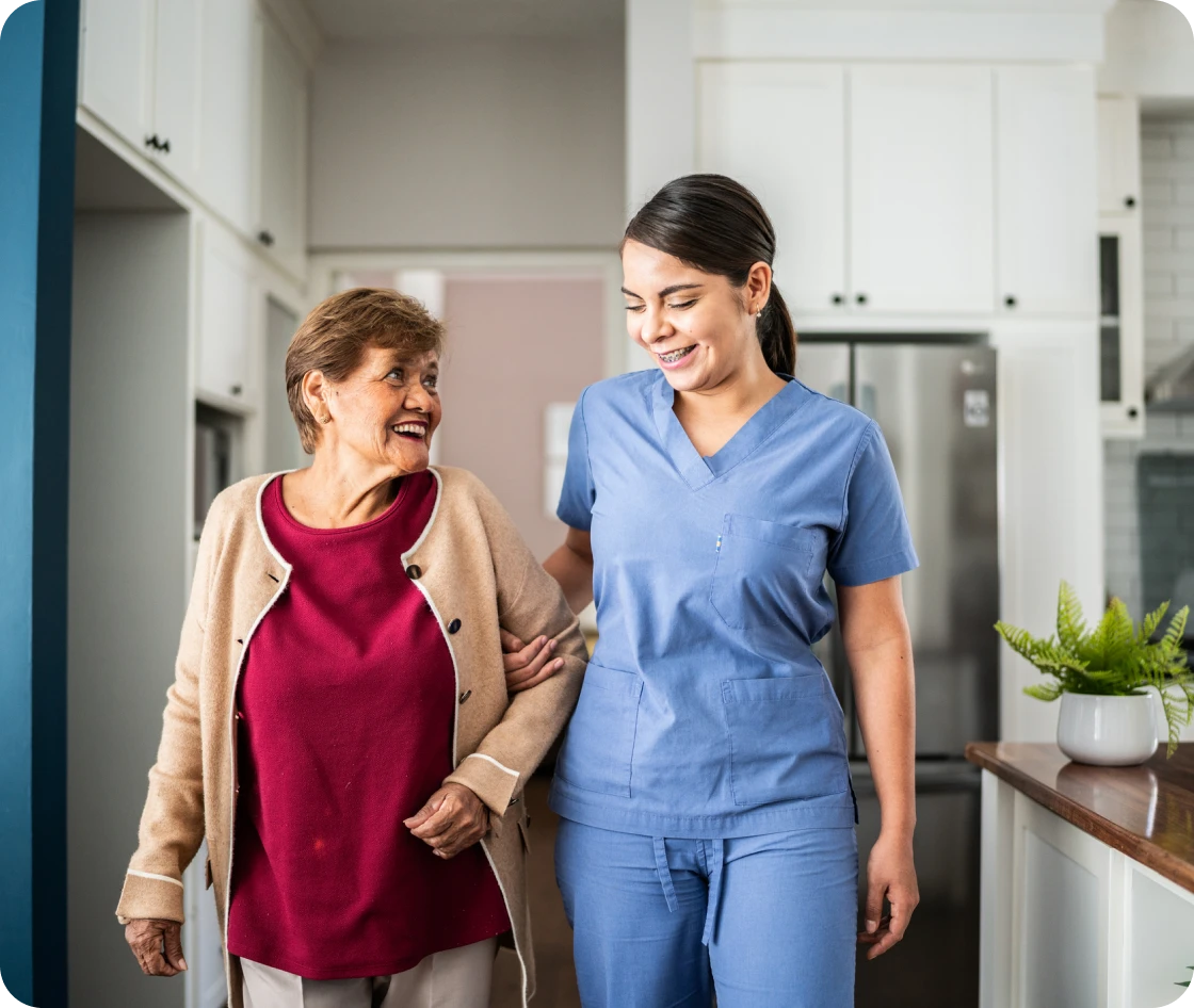 Elderly woman walking with caregiver