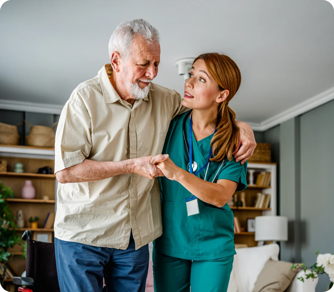 Caregiver helping senior man stand