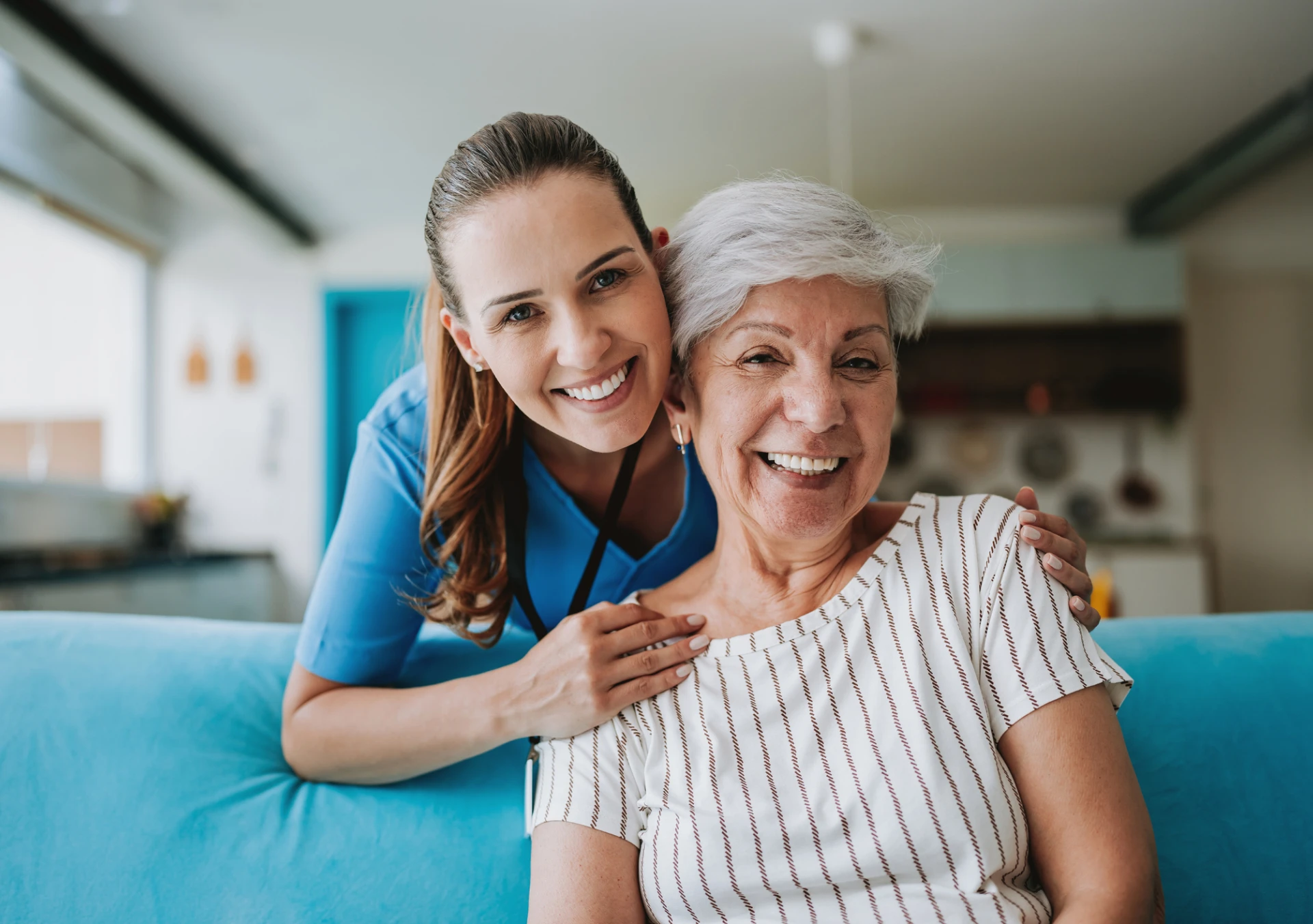 Caregiver and elderly woman smiling together