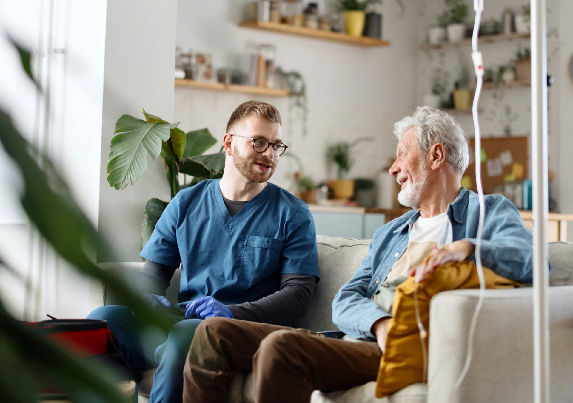 Healthcare worker talking with senior man at home.